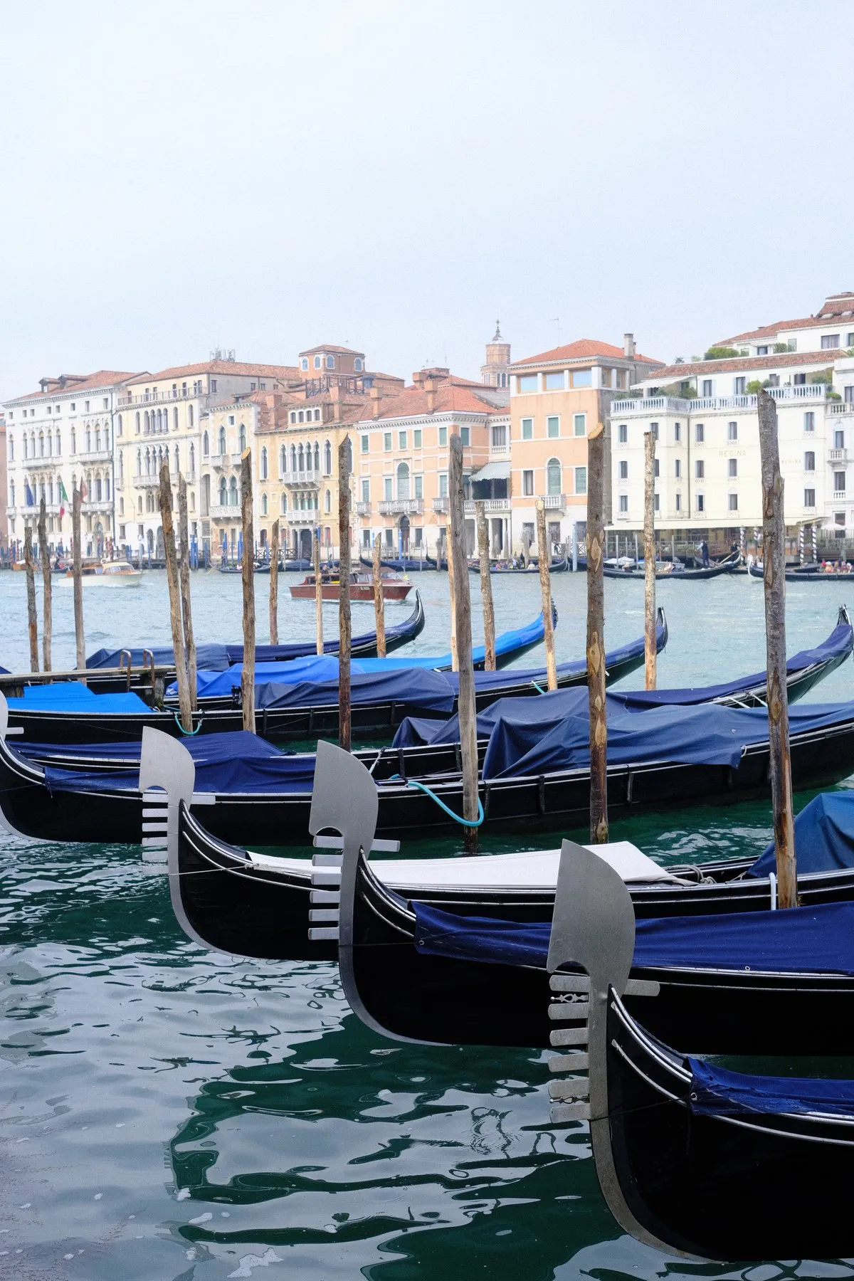 Gondolas moored in front of pastel waterfront buildings